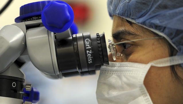 Researcher using a microscope