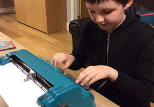 A boy typing in braille